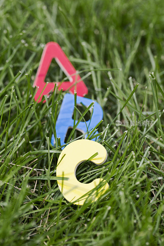 字母A, B和C在绿色的草地上
